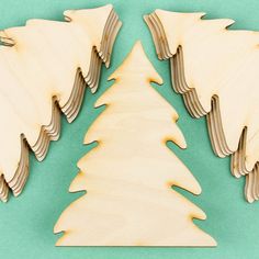 three wooden christmas trees on a green background