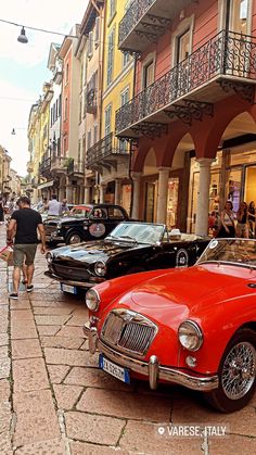 an old red car parked on the side of a street