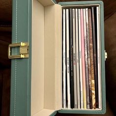 an old record player is opened to show the records in it's storage compartment