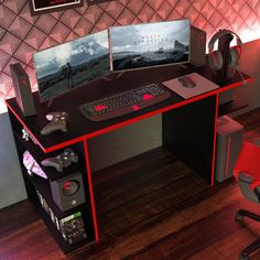 there is a desk with two monitors and a keyboard on it in front of a red chair