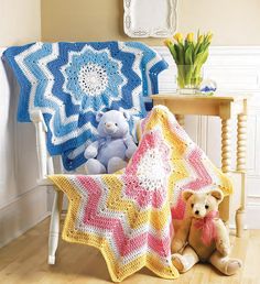 a teddy bear sitting in a chair next to a crocheted blanket