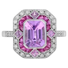 Make a powerful statement in pink. This 18k white gold ring features a perfect sparkly emerald cut pink kunzite set into an octagon shape setting. The center stone is framed in French cut ruby with pink sapphires in north, south, east, and west, finished with outer diamond accent. Ring Information Style: Art-deco Metal: 18K White Gold Total weight: 4.97 g. (approx. total weight) Center Gemstone Type: Pink Kunzite Shape: Emerald Cut Size: 8 x 6 mm. Number: 1 Weight: 2.16 Carat (approx.) Accent Ge Luxury Pink Sapphire Classic Diamond Ring, Pink Diamond Engagement Ring, Pink Engagement Ring, Sapphire Diamond Engagement, Diamond Sapphire Engagement Ring, Pink Kunzite, Custom Jewelry Box, Octagon Shape, French Cut