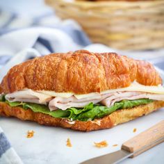 a croissant sandwich with meat, cheese and lettuce