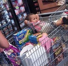 a baby sitting in a shopping cart with milk