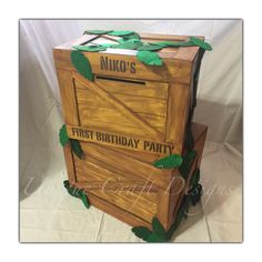 a wooden box with leaves on it that says niko's first birthday party