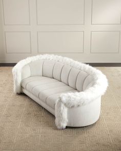 a white couch sitting on top of a carpeted floor next to a wooden door