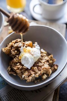 a bowl filled with granola, yogurt and honey