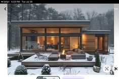 an image of a house in the snow with candles on it's patio and fire pit