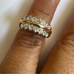 a woman's hand with two gold rings on top of her finger and one has three diamonds in the middle