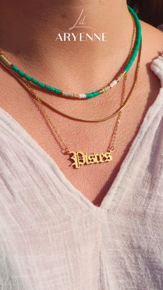 a woman wearing three different necklaces with the word jesus written on one side and an arrow in the middle