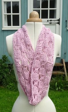 a white mannequin wearing a pink knitted scarf