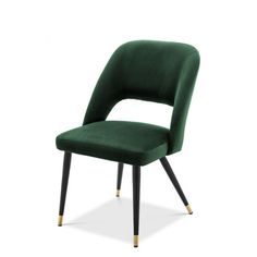 a green velvet chair with gold legs