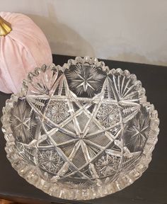 a glass bowl sitting on top of a table next to a pink pumpkin and some other decorations