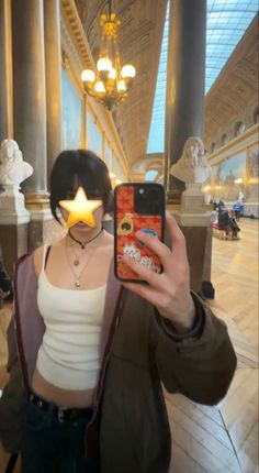 a person taking a selfie with a star on their face in a large building