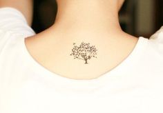 a woman's neck with a tree tattoo on the left side of her neck