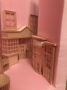 a doll house made out of wood and pink walls