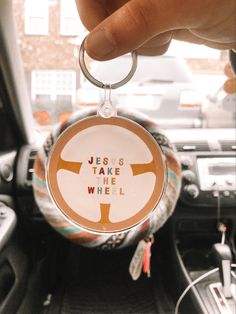 a person holding a keychain that says jesus take the wheel