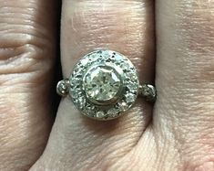 a woman's engagement ring with an old cut diamond in the center, on her finger