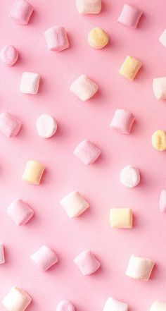 marshmallows on a pink background with white and yellow ones in the middle