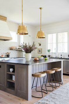 a kitchen island with three stools next to it