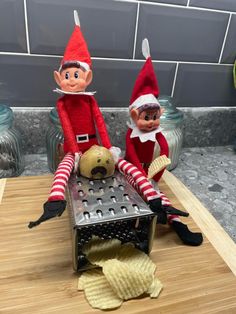 two elfs sitting on top of a table with potato chips