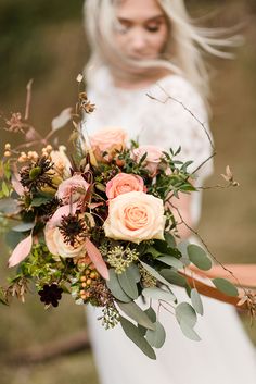 a woman holding a bouquet of flowers in her hands