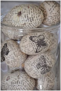 some kind of glass jar filled with lots of paper mache eggs and butterflies on them