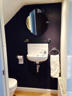 a white sink sitting next to a toilet under a mirror on a wall above a radiator