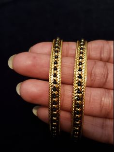 "* Handcrafted Gold Plated 2 Bangle Set. Sold as a set. * Bangles with prettY Black and gold color beads. * High Quality 22 K Gold Plated- 2 Bangle set * Size 2.6 has 2.40\" inner circle diameter; size 2.8 has 2.53\" inner circle diameter Gorgeous gold-plated bangle/ bracelet best exemplifies the careful craftsmanship done on it -- a specialty at Nemali Jewelry. It has a special tone of elegance attached to it. The intricate handmade design of the bangle/bracelet set gives it a fresh and origina Traditional Gold Bracelets With Black Beads, Traditional Gold Beaded Bracelet With Black Beads, Traditional Gold Bracelet With Black Beads, Gold Beaded Bangle Jewelry, Gold Bracelet Jewelry With Black Beads, Gold Bracelet With Black Beads Jewelry, Gold Bangle With Round Beads For Party, Gold Party Bangle With Round Beads, Gold Metal Beaded Bracelets For Festive Occasions