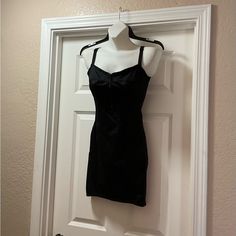 a black dress hanging on a white door