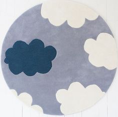 a blue and white rug with clouds on the top in front of a white wall