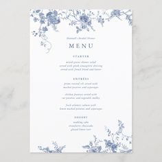 a blue and white menu card with flowers on the front, sitting on a marble surface