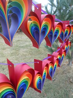 colorful paper hearts hanging from a line in the grass