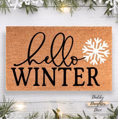 a door mat with the words hello winter on it and snowflakes around it