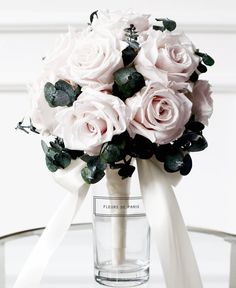 a bouquet of white roses in a clear vase