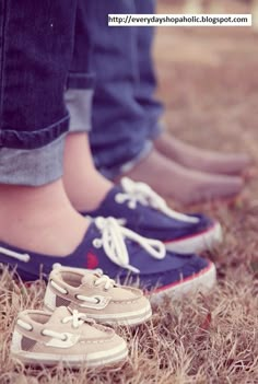 two people standing next to each other with shoes on the ground in front of them