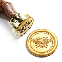 a wax stamp with a bee on it next to a wooden rubber stamper that says bees