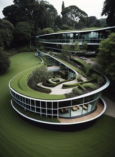 an aerial view of a circular building with green grass on the ground and trees in the background