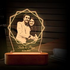 a personalized illuminated photo on a wooden stand with the name and date printed on it