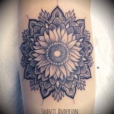 a black and white photo of a sunflower tattoo on the right side of the thigh