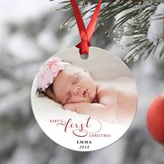 a baby's first christmas ornament hanging from a tree