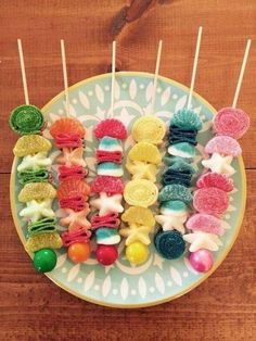 colorful candies are arranged on a plate with toothpicks in the shape of animals