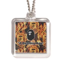 a bathing ape necklace with flames in the background and an image of a gorilla on it