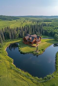 an aerial view of a large house in the middle of a field with a pond