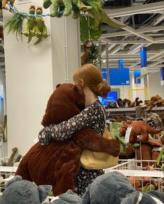 a woman is hugging a stuffed animal in a room full of stuffed animals and toys