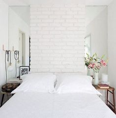 there is a white brick wall in the bedroom