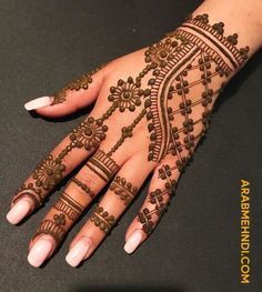 a woman's hand with henna tattoos on it