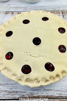 an uncooked pie with cherries on it