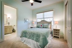 a bedroom with a bed, dresser and ceiling fan in the middle of the room