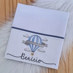 a white towel with a blue hot air balloon on it and the word bunito written in cursive writing